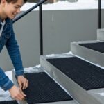 階段にマットを敷く男性